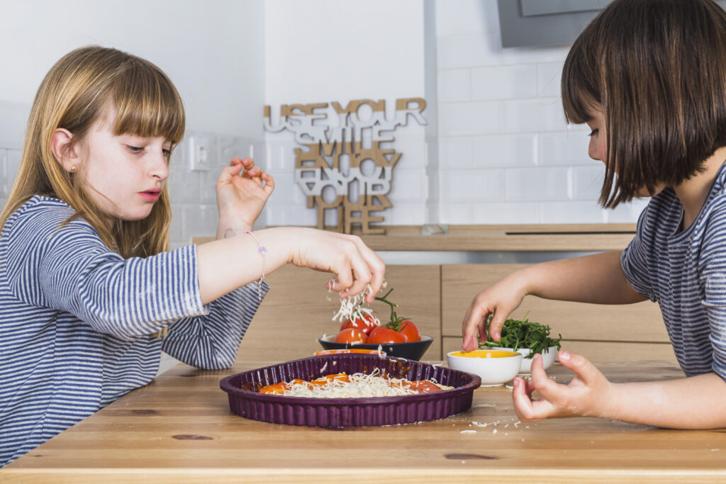 2 kids making pizza